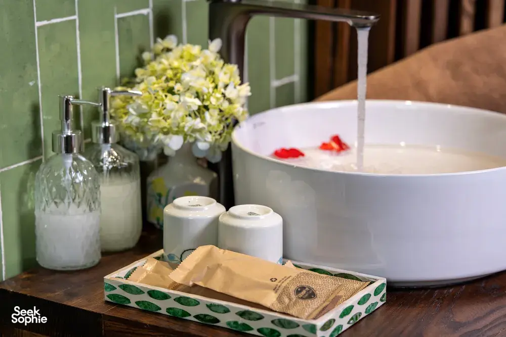 Toiletries and a white bath basin on a wooden table in Cat Ba Ocean Cruises’ cabin for the 3D2N Cat Ba cruise