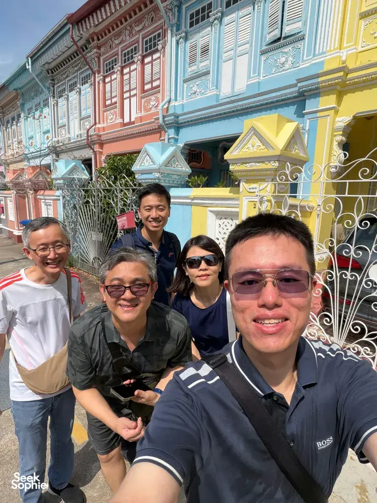 Team members smiling for a selfie outside Peranakan shophouses in Katong-Joo Chiat during a Monopoly-style trail in Singapore hidden gems.