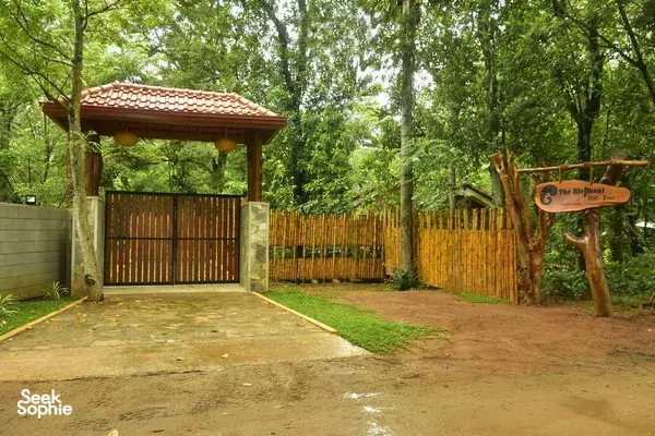 Garden entrance gate to cottages at The Elephant Next Door in Udawalawe, set in a quiet leafy garden with a paved walkway