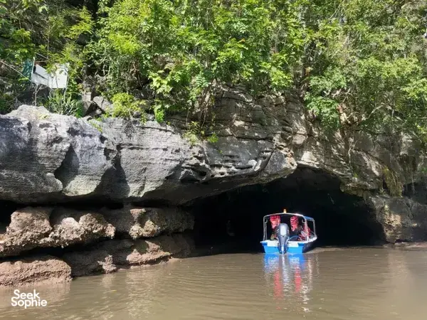 Boat drifting into a limestone cave along Langkawi’s UNESCO Geopark waterways during the cruise