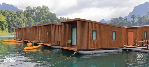 考索国家公园湖上的木质漂浮式豪华露营小屋,甲板旁停泊着皮划艇