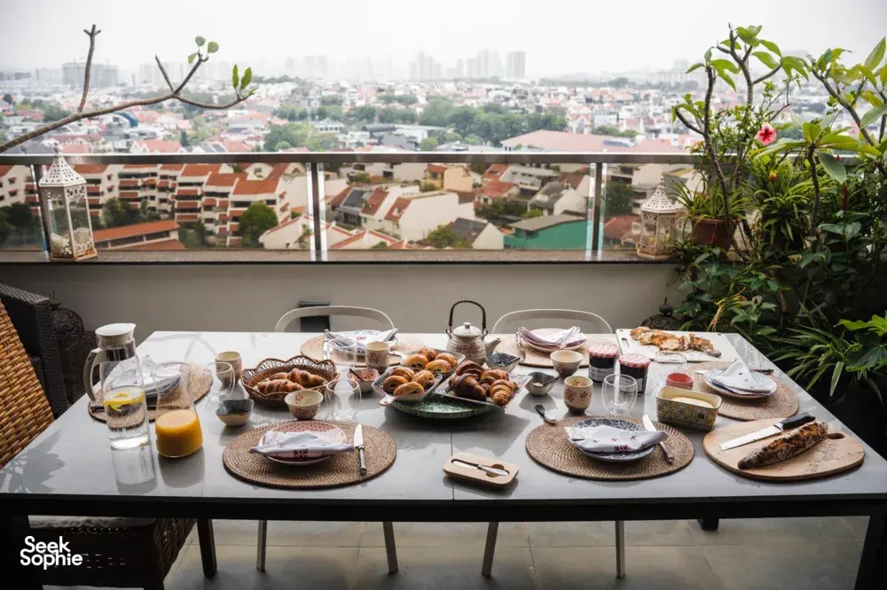 Croissant-tasting table on a rooftop terrace in Singapore with trays of pastries and teacups for workshops in Singapore