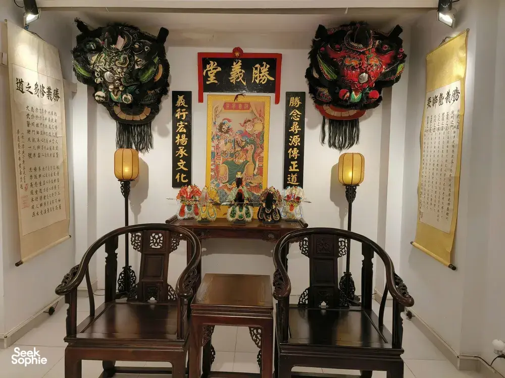 Ho Chi Minh City Chinatown lion-dance heritage room display with ornate lion heads, festive banners and a ceremonial altar