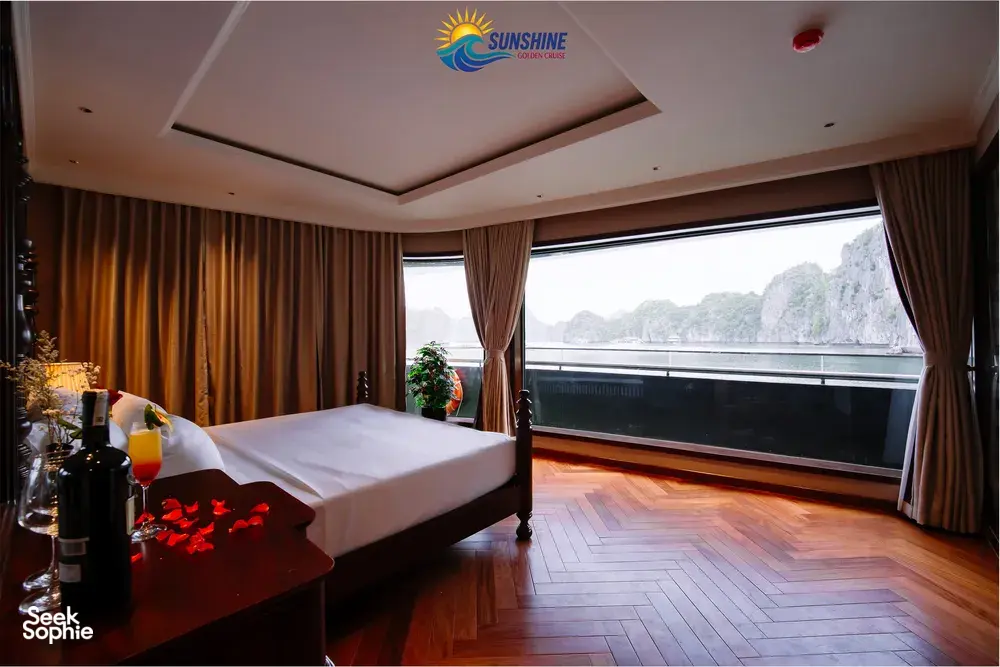 Sunshine Golden Cruises cabin with a king bed, floor-to-ceiling curtains and a large window looking out over the water