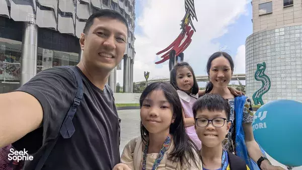 Smiling guide with children pose outdoors in Singapore during a Kampong Gelam heritage adventure, uncovering Singapore hidden gems
