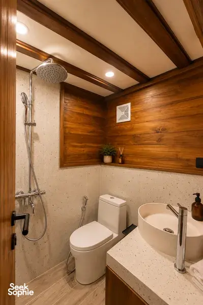 Travass Life new phinisi bathroom with a shower, toilet and countertop sink built into wood and stone, on a Komodo Island trip