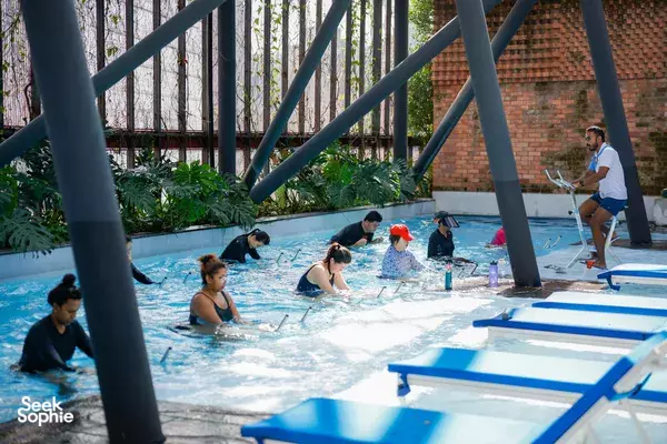 Indoor The Ripple Club Aquaspin class with participants on aqua bikes and an instructor supervising at Paradox Singapore Merchant Court