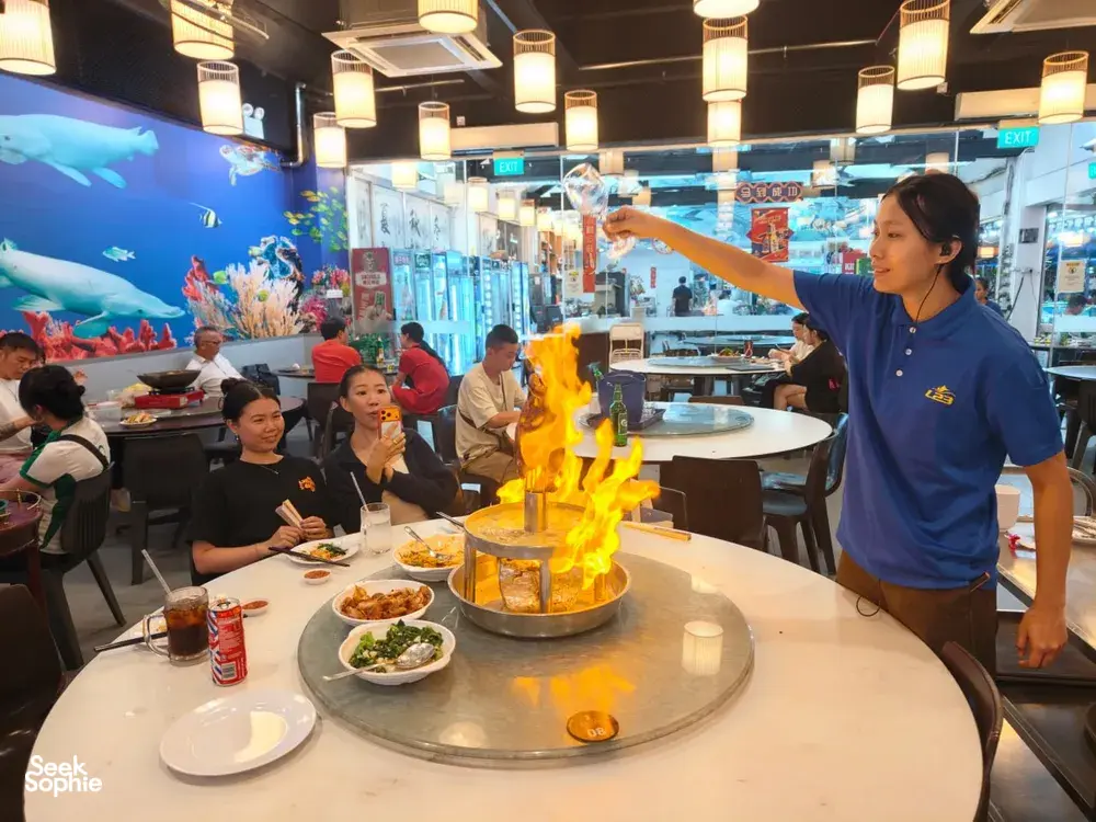 Diners around a round table watching a flame centerpiece at a Geylang-area Singapore restaurant during a private night walk