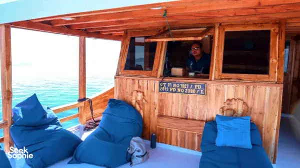 Fanie Boat Tours wooden dive liveaboard deck with blue cushions and ocean view on the 3-night Komodo cruise from Labuan Bajo