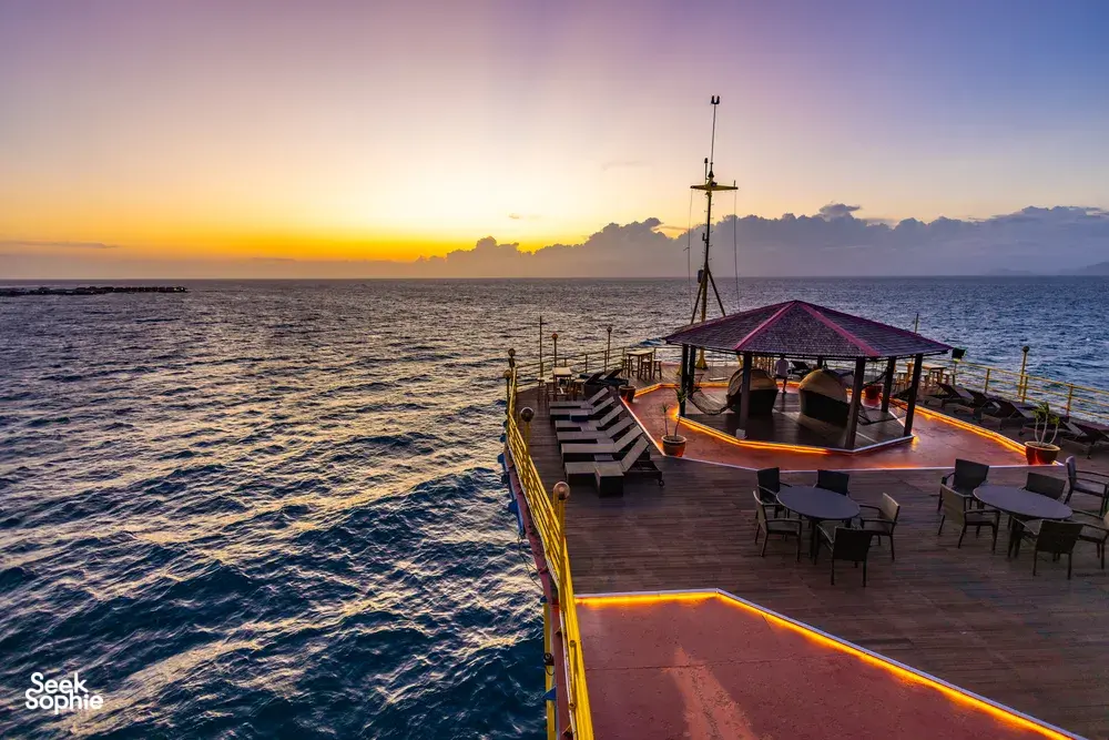 Wooden deck on the Seaventures Dive Rig at sunrise near Semporna, with chairs overlooking the South China Sea