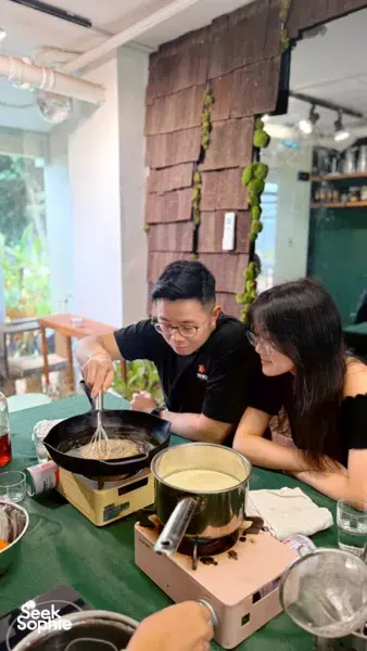 Two hosts from The Unexpected stir a honey base on a stovetop while making craft honey ice cream in Singapore, workshops in Singapore