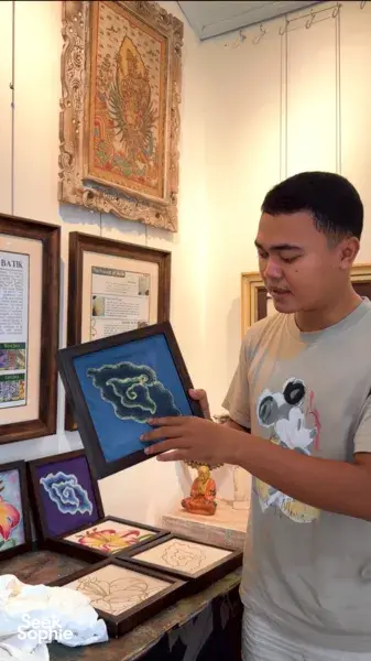Visitor examining a framed batik artwork at Five Arts Studio in the Balinese art compound in Keliki, Ubud