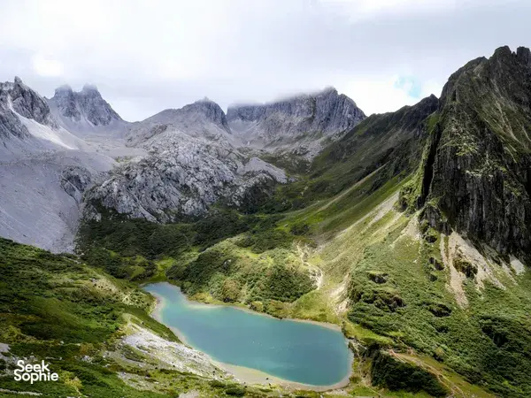 Turquoise alpine lake cradled in green mountains along the Tiger Leaping Gorge region near Shangri-La