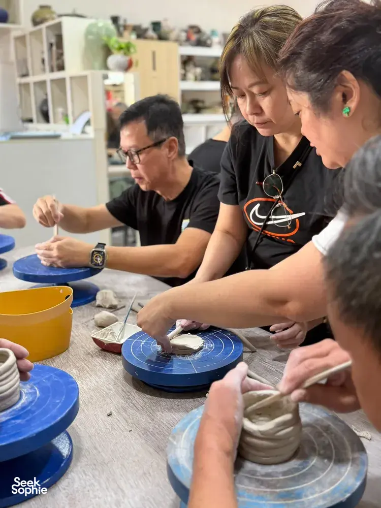 Tangan membentuk tanah liat di roda putar di studio 3Arts Pottery di Singapura — workshop di Singapura