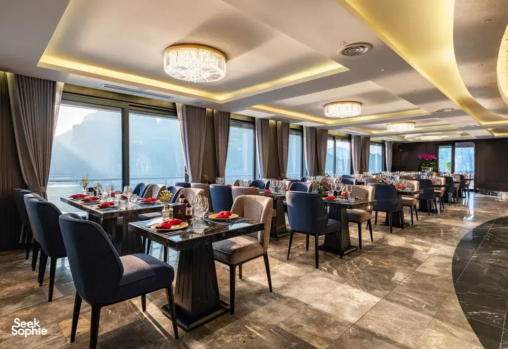 Elegant 5-star breakfast dining area on Doris Cruise with neatly arranged tables and large sea-view windows in Halong Bay