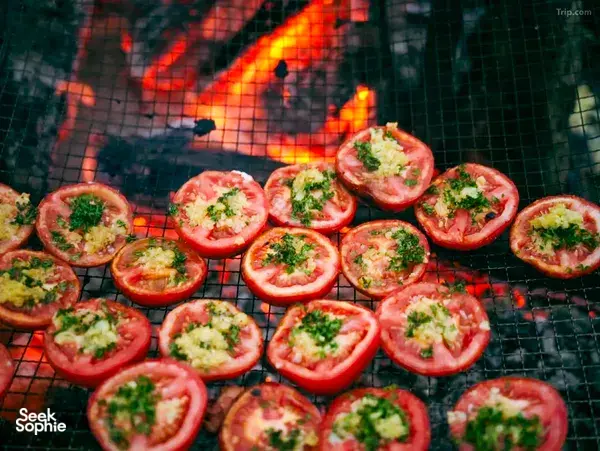 Halved tomatoes with herbs grilling on a camp barbecue during a 2D2N Tibetan valley stay with Caravan Treks by Ferme Liotard in Shangri-La