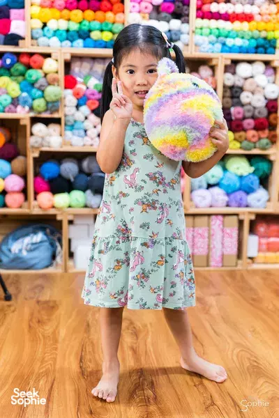 Child holding a colourful plush toy they made at Tiny Rabbit Hole’s studio in Singapore for workshops in Singapore