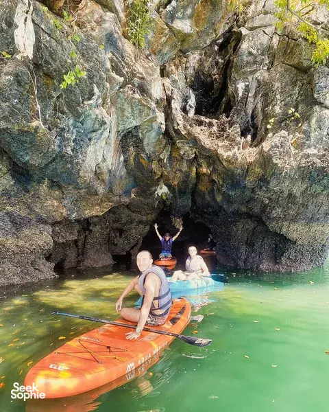 Group kayaking on stand-up paddleboards in a sea cave near Tanjung Rhu cliffs, Langkawi’s calm waters