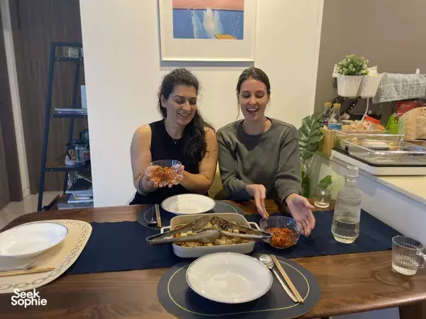 Two diners preparing kimchi and other Korean dishes at a Singapore dine-in cooking session in a home kitchen