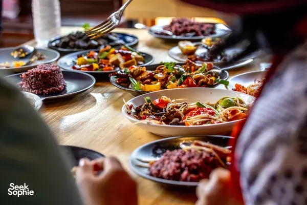 Forage-to-table feast at a Mae Kampong cooking class in Chiang Mai, with colourful plated dishes laid out on a wooden table