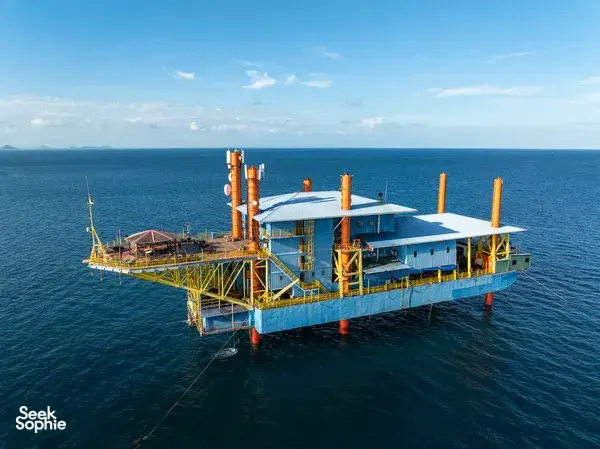 Retired oil rig turned dive base, the Seaventures Dive Rig floating offshore in the blue sea near Semporna