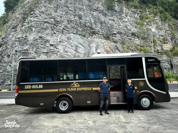 Son Tung Express bus shown side-on at a mountain roadside stop near Cat Ba for the Halong to Cat Ba bus transfer