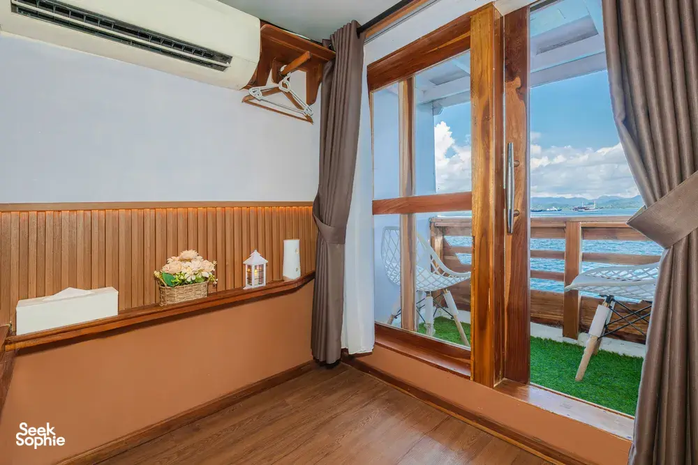 Bright boat-cabin room with open wooden door and sea-view balcony outside, La Famille 3D2N Join-In Komodo trip in Labuan Bajo