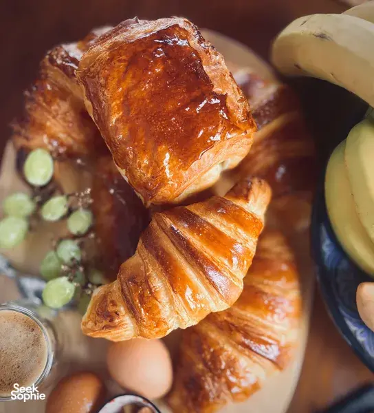 Croissant berlapis di atas pinggan dengan telur dan anggur di sisi kopi semasa bengkel French Cooking Lab di Singapura