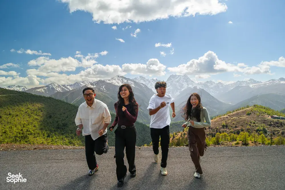 Travellers walking along a ridge above Shangri-La’s mountain landscape, enjoying clear views during a 6-day Loop with a Tibetan guide