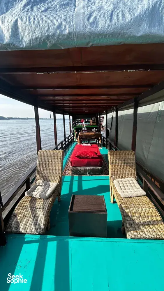 Small boat deck with cushioned loungers and open windows along the water on a 3D2N Sister Tour cruise, Tanjung Puting