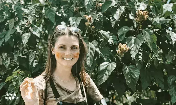 Smiling traveller among flowering coffee trees near Da Lat during the Easy Rider journey to Mui Ne in Vietnam