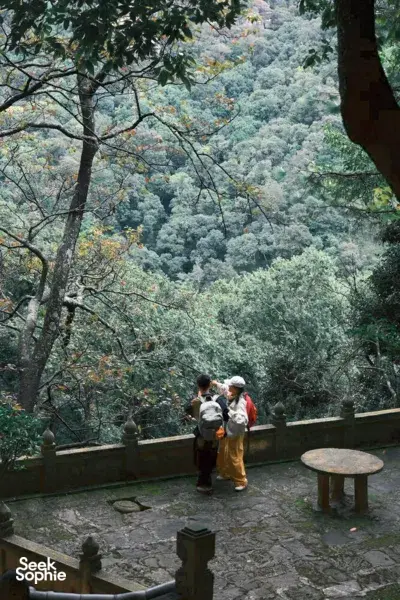 Visitors on a temple walkway looking over lush misty hills near Shaxi, Dali during the eco retreat