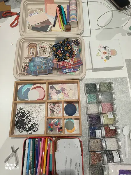 Overhead view of Gemstory vision-boarding supplies and finished collages in the studio for workshops in Singapore