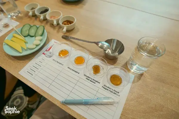 Fish sauce tasting chart with labelled bowls, spoons and water glass on the table during a Saigon Social experience in Ho Chi Minh City