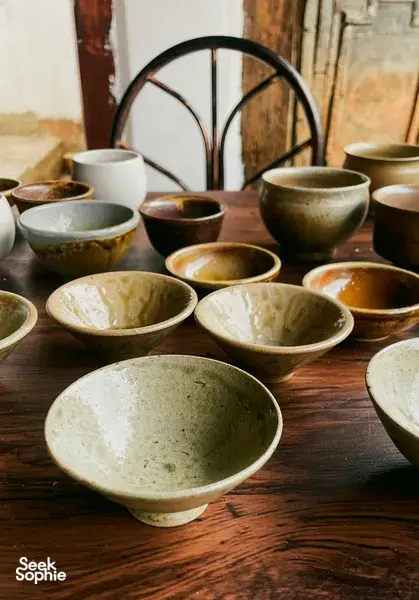 Handmade ceramic bowls arranged on a wooden table during Jay’s host-led Ancient Pottery Village Visit in Dali