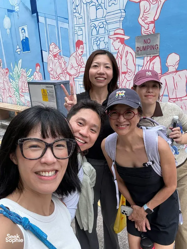 Group posing in front of a street mural in Katong-Joo Chiat during a real-life Monopoly team game in Singapore, team building Singapore