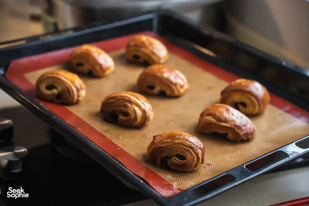 Golden croissants arranged on a parchment-lined baking tray in a Singapore oven, ready for workshops in Singapore