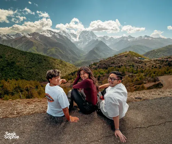 Travellers posing on a mountain viewpoint during the Shangri-La Loop with a Tibetan guide in Shangri-La