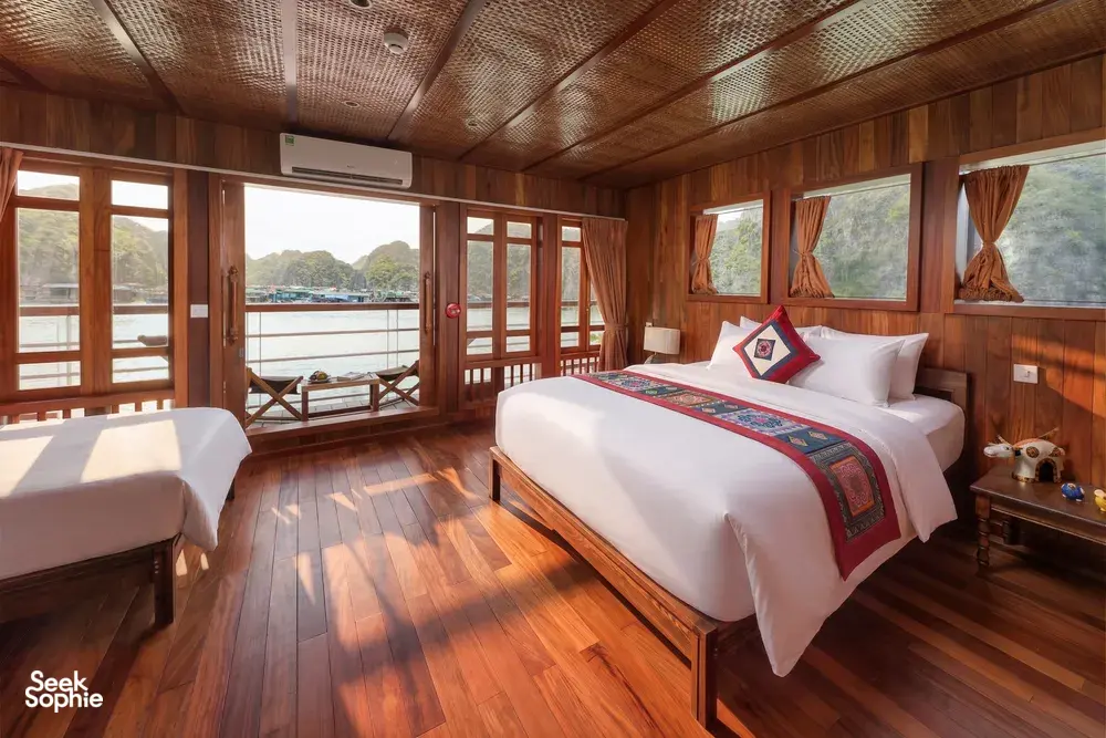 Cat Ba Ocean Cruises wooden cabin on a Cat Ba Boutique Cruise, with twin beds and sea views through large windows