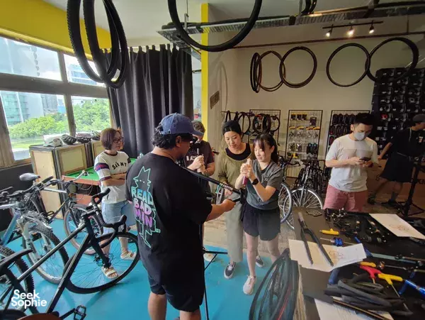 Guided bicycle build inside Unspokin’s showroom in Singapore, as participants fit parts to frames at workbenches—workshops in Singapore