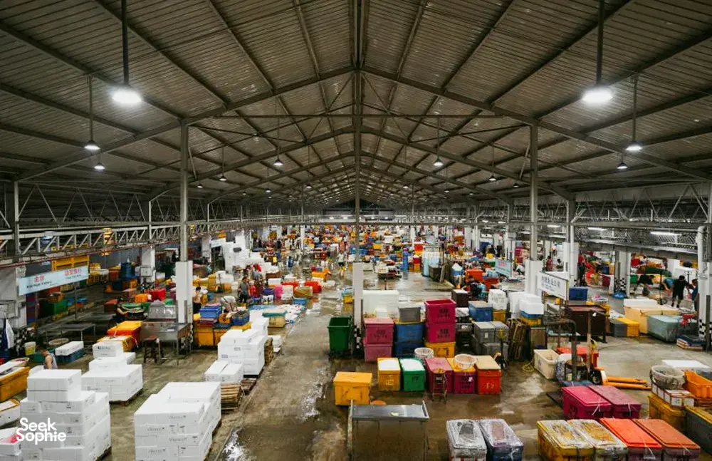 Balai pasar gudang indoor yang luas di pelabuhan Jurong, Singapura, dipenuhi barang dalam kotak dan kios—permata tersembunyi Singapura