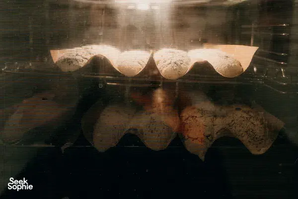 Golden baguettes baking in a windowed oven in a cosy loft in Singapore, part of French Cooking Lab workshops in Singapore