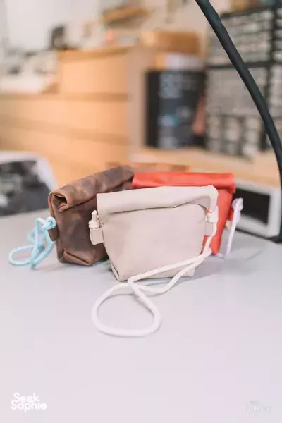 Handmade leather bags in different colours on a workshop table in Singapore at New Bahru, workshops in Singapore