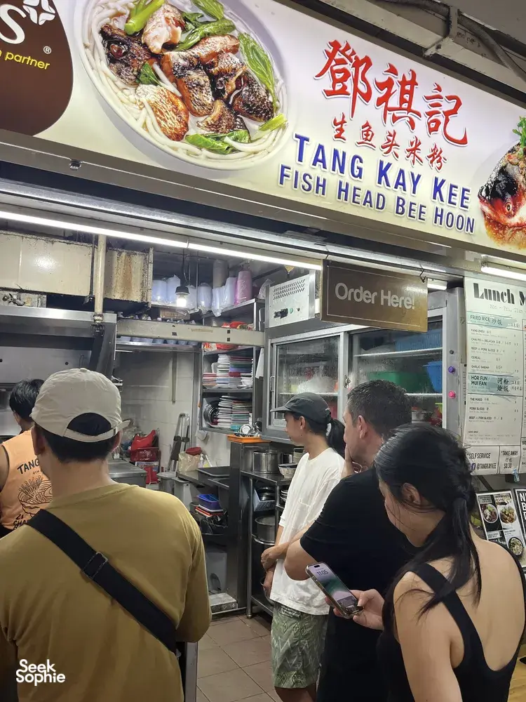 Diners queueing at the Tang Kay Kee hawker stall in Chinatown Singapore, viewing the fish head bee hoon menu