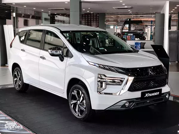 White Mitsubishi Xpander MPV displayed in a showroom, Ho Chi Minh City transport option for renting or buying
