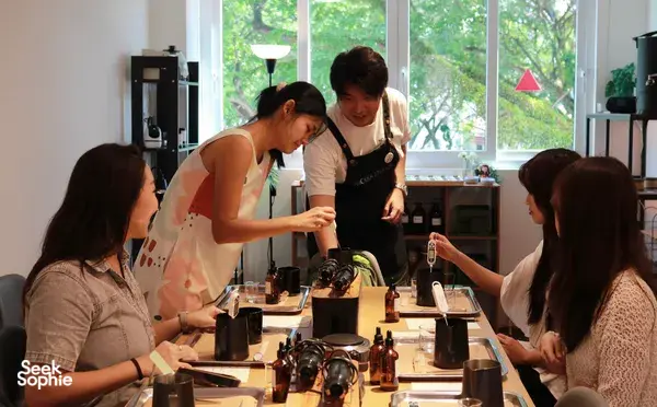 Guests pouring wax during WICKKA STUDIO crystal candle making & manifestation candle workshop in Singapore, guided by the host