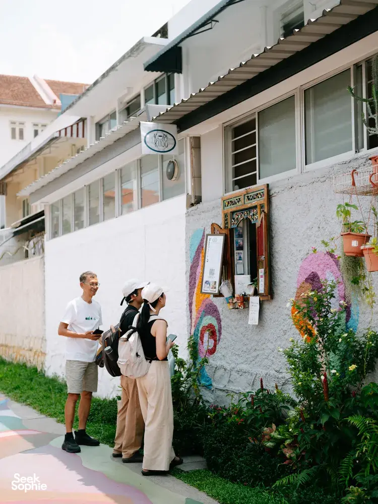 Tour group walking past colourful shophouses and wall art on Joo Chiat streets during a food tour, Singapore hidden gems