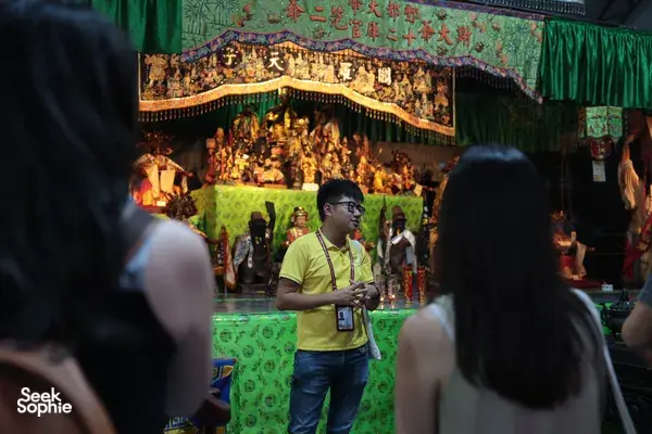 Hey Lad Tour guide speaking with visitors beside a Chinese temple altar during Hidden Chinese Rituals at night in Singapore, Singapore hidden gems