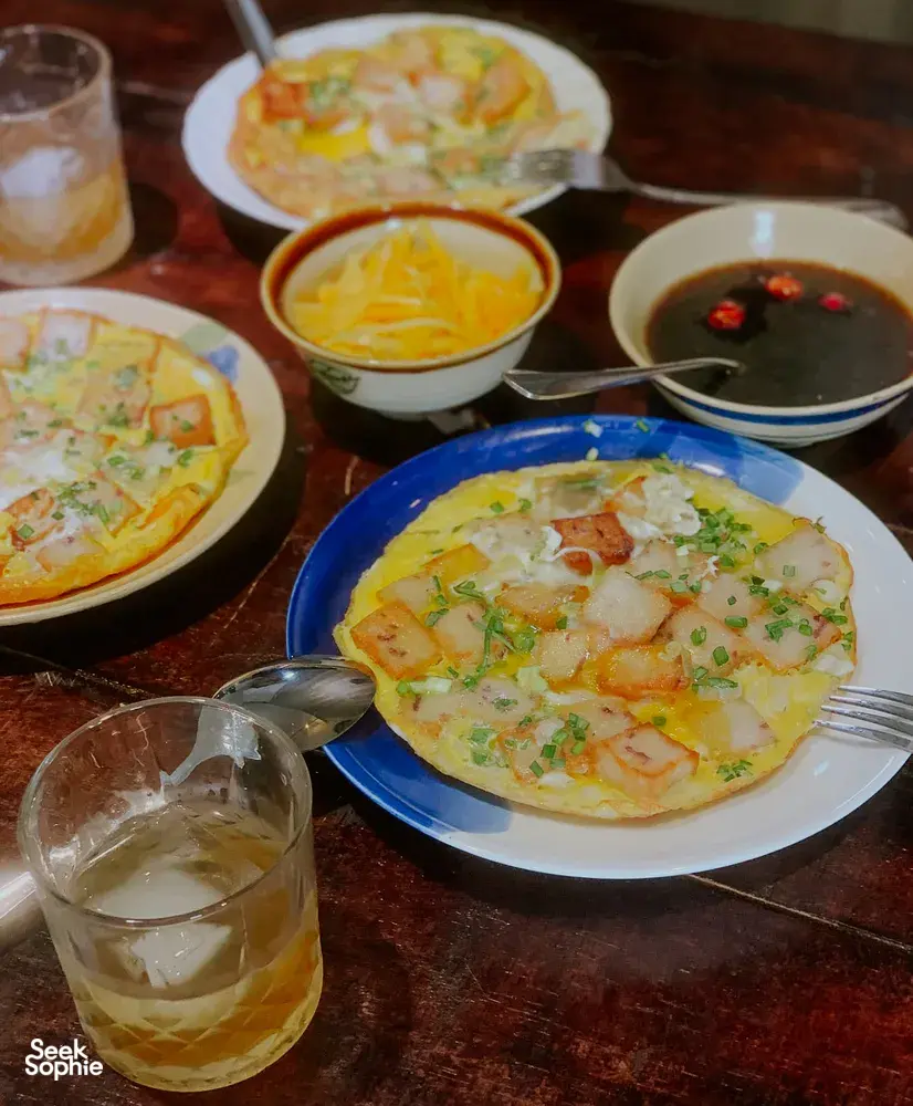 Pengalaman cita rasa budaya di Chan Dat Living Room, Hoi An, dengan gelas wain, mangkuk sup dan pembuka selera terhidang di atas meja makan