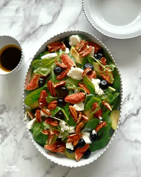 Ornate European-style ceramic plates with a mixed salad of greens, feta, olives and herbs, set on a marble surface workshops in Singapore